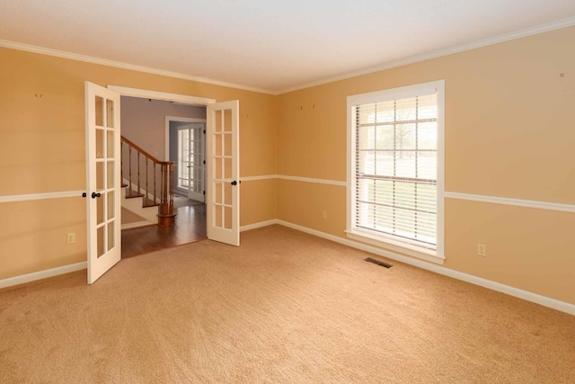 unfurnished room with carpet floors, crown molding, french doors, and baseboards