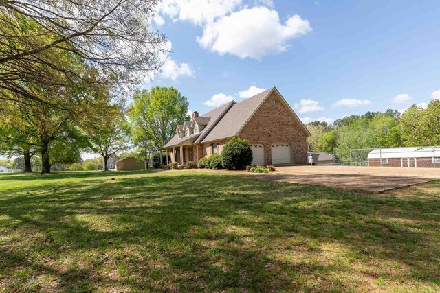 view of side of home featuring a lawn, brick siding, dirt driveway, and a garage