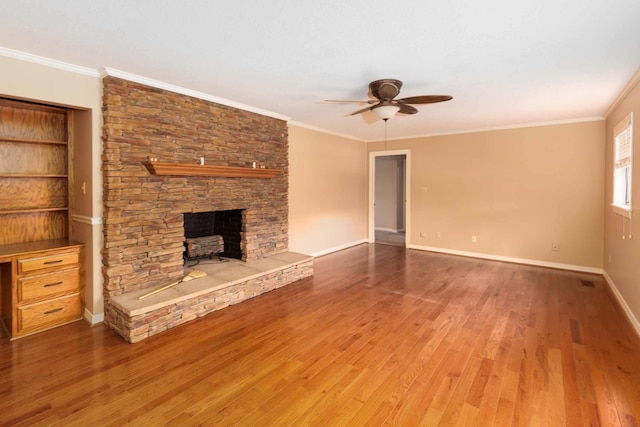unfurnished living room featuring a ceiling fan, wood finished floors, a fireplace, and ornamental molding