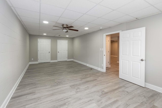interior space with light wood-style flooring, a drop ceiling, baseboards, recessed lighting, and a ceiling fan