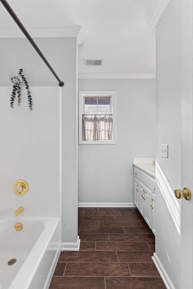 bathroom featuring crown molding, washtub / shower combination, and vanity