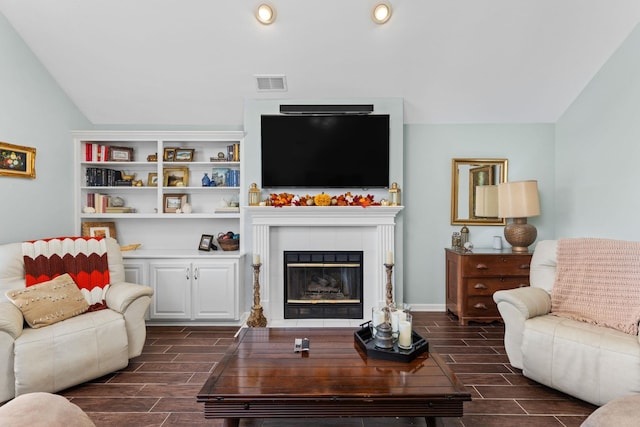 living room featuring vaulted ceiling and a tile fireplace