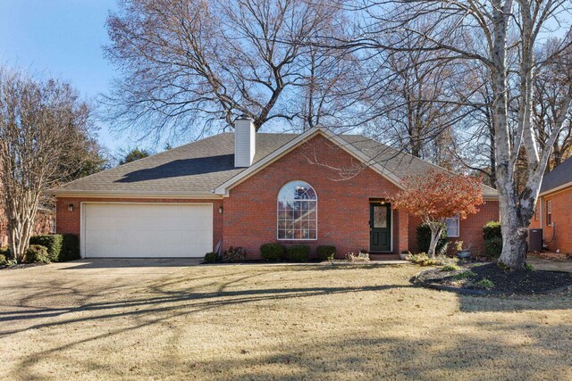 view of front of property featuring central AC unit, a garage, and a front lawn