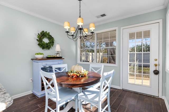 dining area with crown molding, a healthy amount of sunlight, and an inviting chandelier