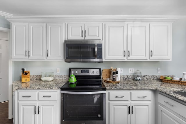 kitchen with white cabinetry, stainless steel appliances, and light stone countertops