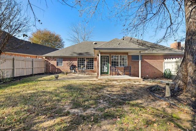 rear view of property with a patio and a lawn