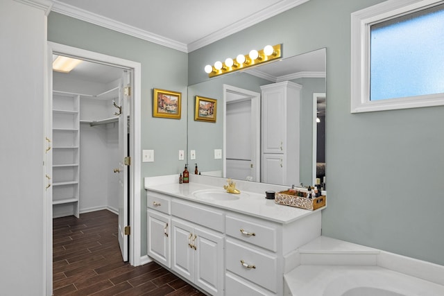 bathroom with crown molding, a washtub, and vanity