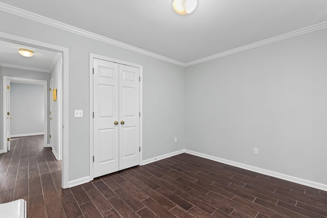 unfurnished bedroom featuring dark wood-type flooring, ornamental molding, and a closet