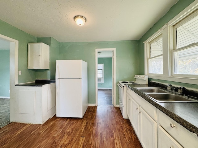 kitchen featuring sink, dark hardwood / wood-style floors, plenty of natural light, white appliances, and white cabinets