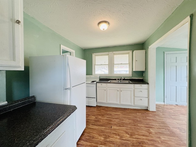 kitchen with a textured ceiling, white appliances, sink, light hardwood / wood-style floors, and white cabinetry