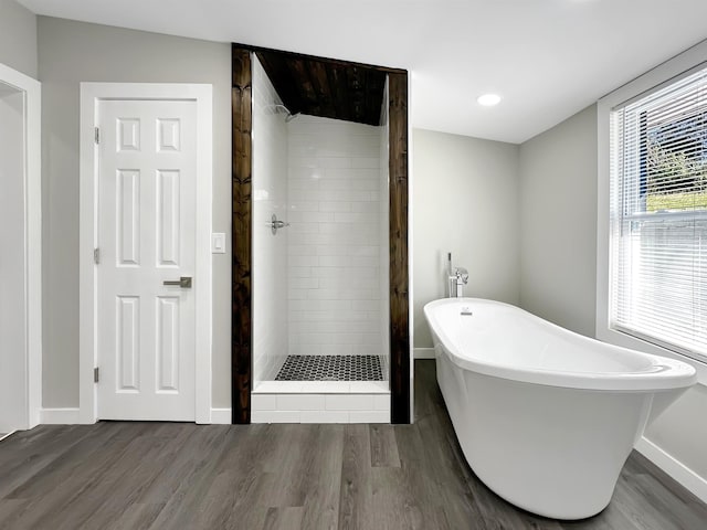 bathroom featuring hardwood / wood-style floors and plus walk in shower