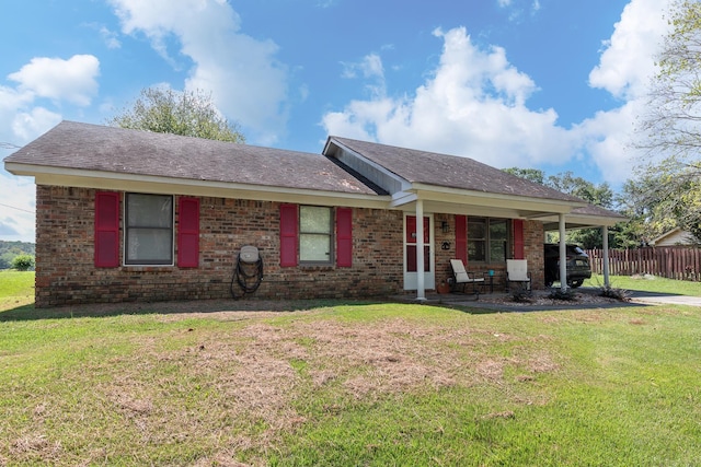 ranch-style home featuring a front lawn and a carport