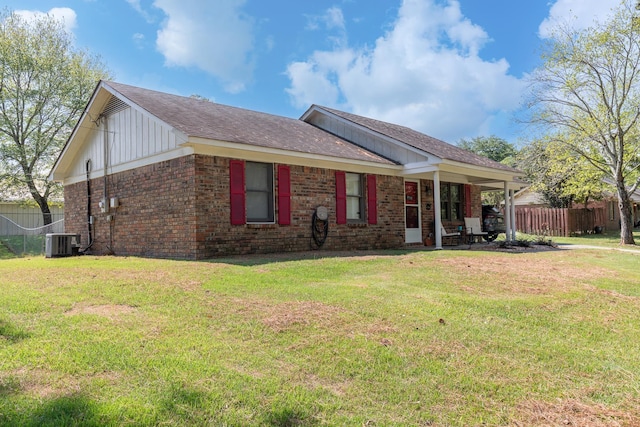 view of front of property with a front yard and central AC