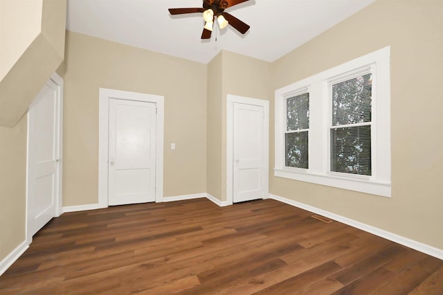 interior space featuring a ceiling fan, dark wood-style floors, and baseboards
