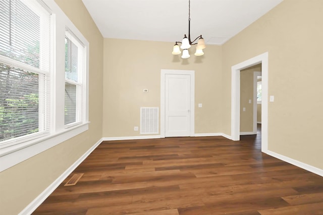 unfurnished room with a wealth of natural light, a notable chandelier, and visible vents