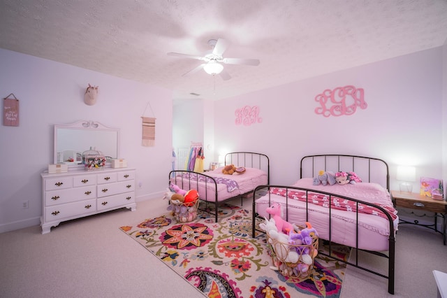 bedroom featuring light carpet, a textured ceiling, and ceiling fan