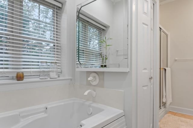 bathroom with independent shower and bath and tile patterned flooring