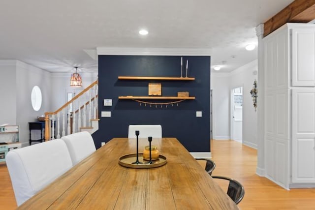 dining room with ornamental molding and light hardwood / wood-style floors