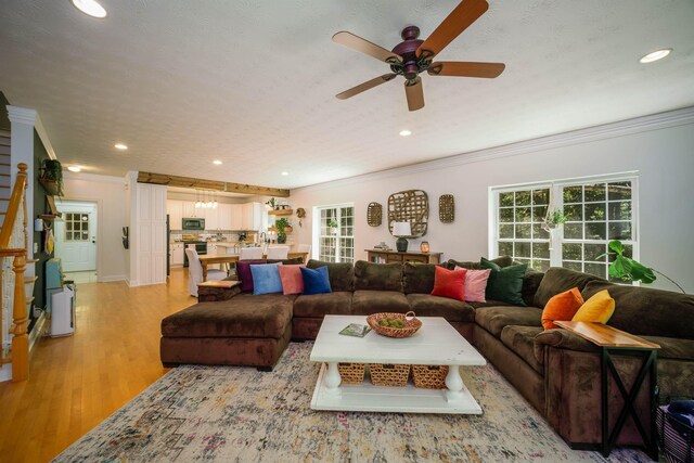 living room with ceiling fan, light hardwood / wood-style flooring, and crown molding