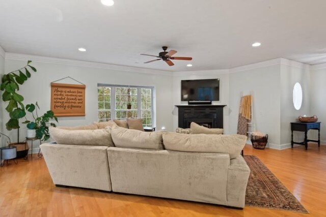 living room with ceiling fan, ornamental molding, a textured ceiling, and hardwood / wood-style flooring