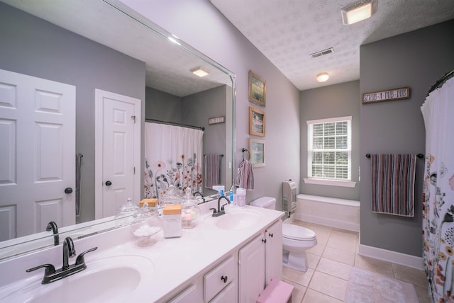 bathroom featuring tile patterned floors, vanity, toilet, and a textured ceiling