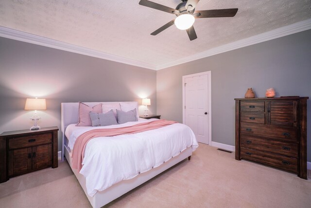 bedroom with a textured ceiling, ceiling fan, crown molding, and light carpet