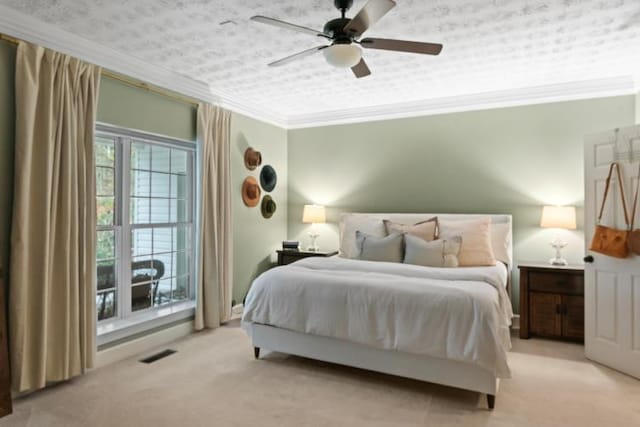 carpeted bedroom featuring ceiling fan, ornamental molding, and a textured ceiling