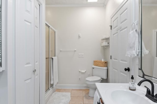 bathroom with a shower with door, crown molding, tile patterned flooring, and toilet