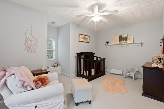 carpeted bedroom with ceiling fan and a textured ceiling