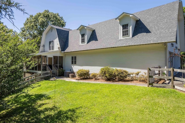 back of house with a lawn, central AC, and a sunroom