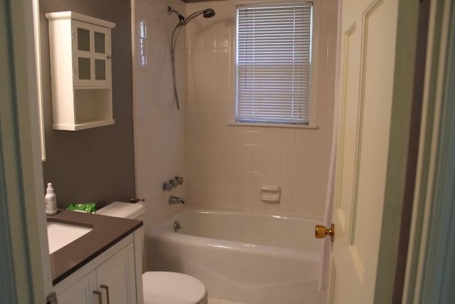 full bathroom with vanity, tiled shower / bath combo, and toilet