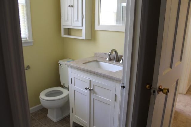 bathroom with tile patterned floors, vanity, toilet, and plenty of natural light