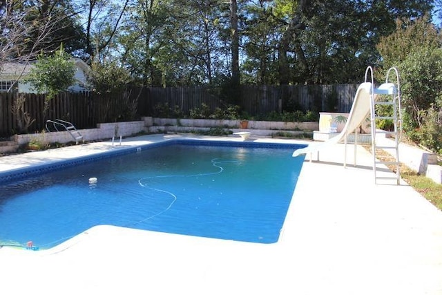 view of swimming pool with a patio and a water slide