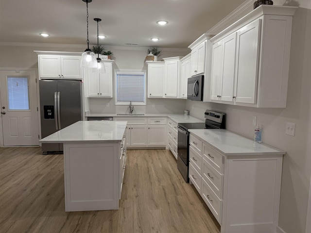 kitchen with decorative light fixtures, white cabinets, a center island, and stainless steel appliances