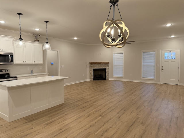 kitchen featuring a chandelier, white cabinetry, light wood-type flooring, decorative light fixtures, and stainless steel appliances