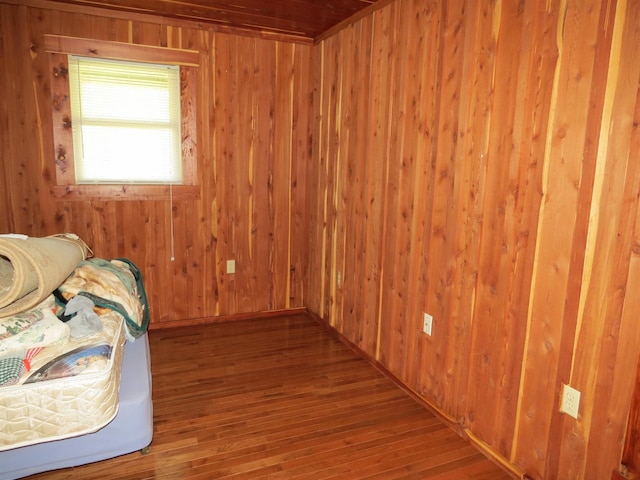 unfurnished bedroom with wooden walls and wood-type flooring