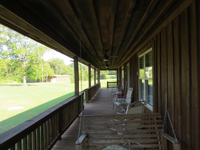 wooden deck featuring a porch and a lawn