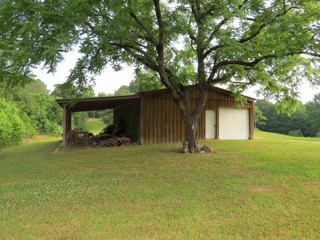 view of yard with a garage and an outbuilding