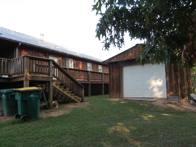 rear view of property with an outbuilding, a garage, and a lawn