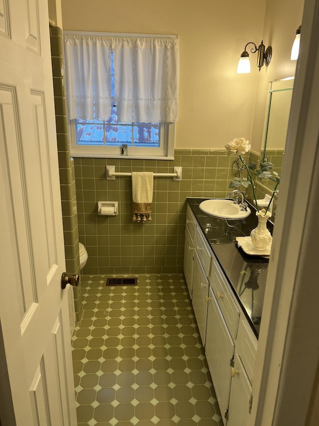  - bathroom featuring vanity, tile walls, and wainscoting