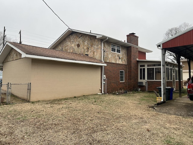  - rear view of property with a chimney, a sunroom, brick siding, a gate, and stone siding