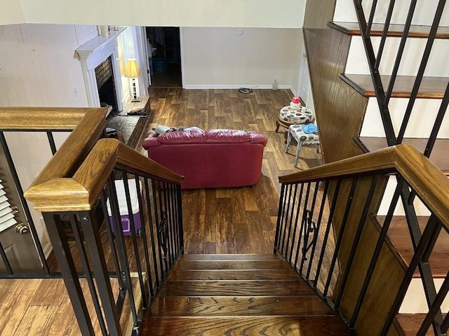  - stairway with wood-type flooring and a fireplace with raised hearth