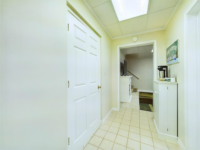 hall with a drop ceiling and light tile patterned floors