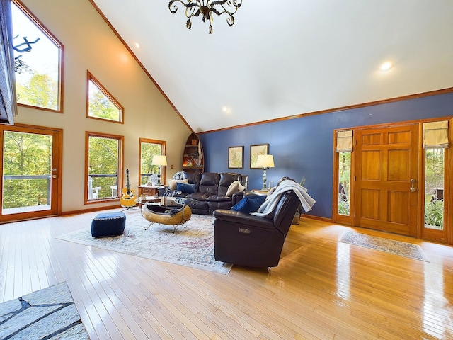 living room featuring a chandelier, light hardwood / wood-style floors, and high vaulted ceiling