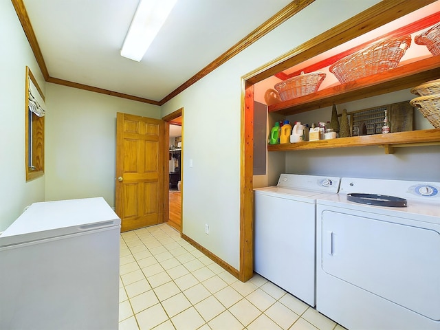 washroom with light tile patterned floors, washing machine and dryer, and ornamental molding