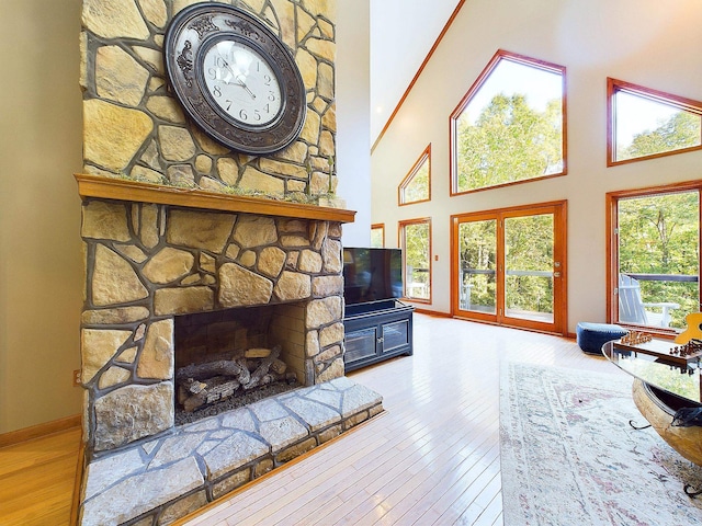 living room featuring a fireplace, wood-type flooring, and a high ceiling