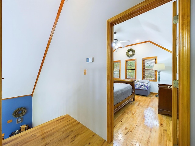 unfurnished bedroom with light hardwood / wood-style flooring, vaulted ceiling, ceiling fan, and ornamental molding