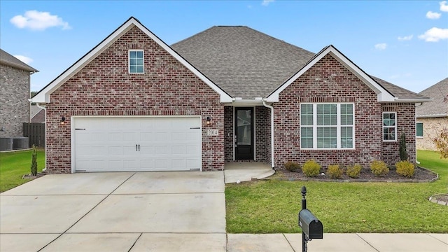 view of front of property featuring central AC unit, a garage, and a front lawn