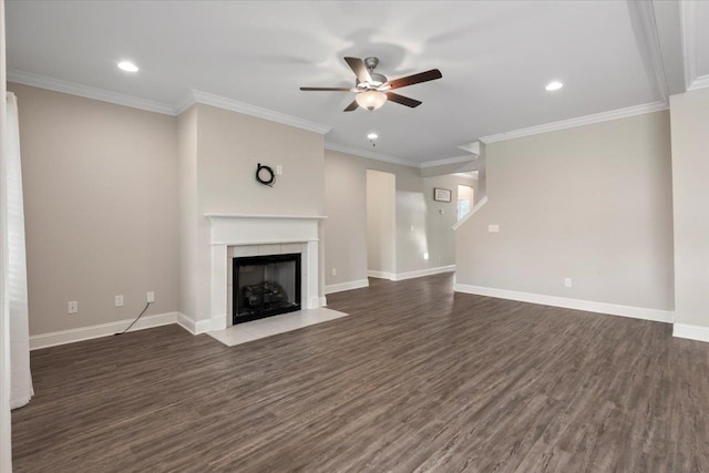 unfurnished living room featuring a tiled fireplace, ceiling fan, dark wood-type flooring, and ornamental molding