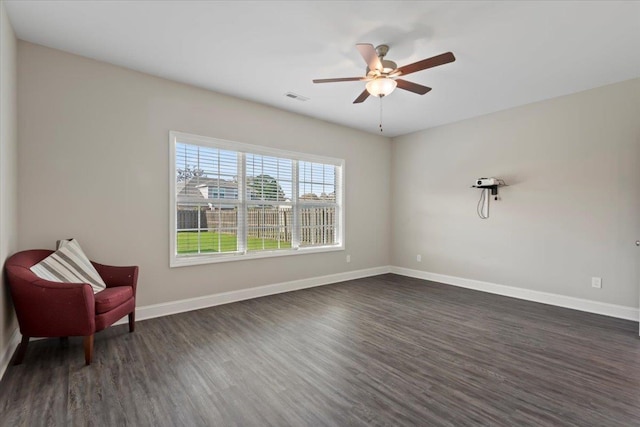 living area featuring dark hardwood / wood-style floors and ceiling fan